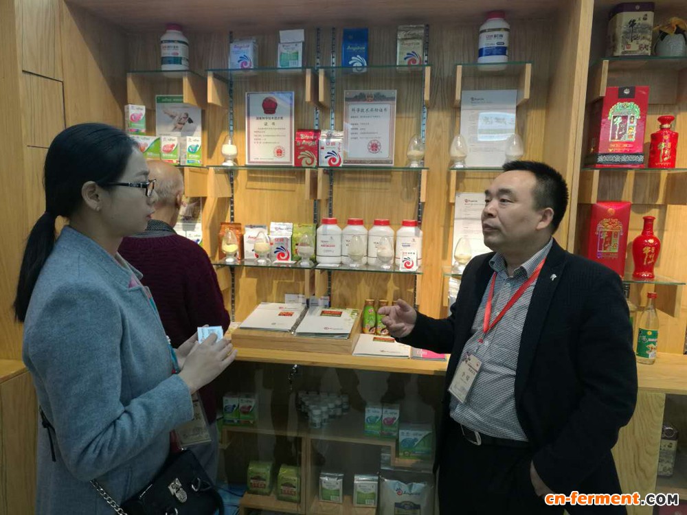 图四：李啸博士在安琪展柜前向客人介绍公司及产品